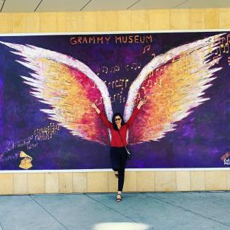 brenda in front of a pair of wings at the grammy museum